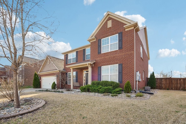 traditional-style house featuring a front yard, an attached garage, fence, and driveway