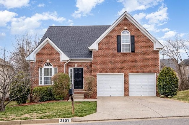 traditional-style home with brick siding, an attached garage, driveway, and roof with shingles