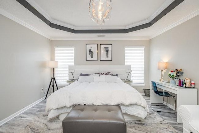 bedroom with a raised ceiling, multiple windows, crown molding, and baseboards