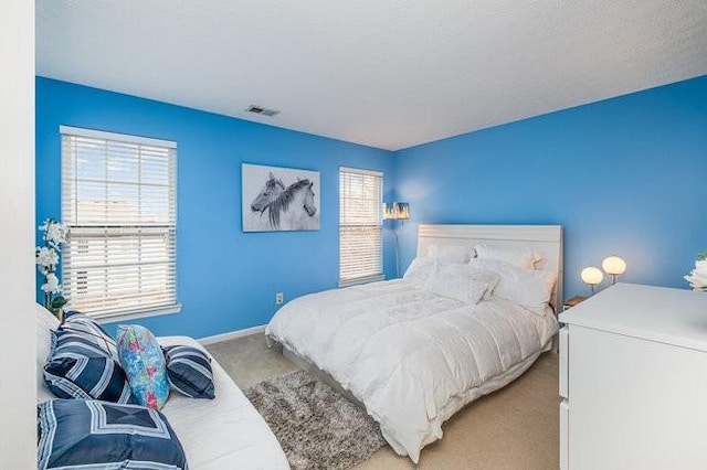 bedroom with baseboards, carpet floors, and visible vents