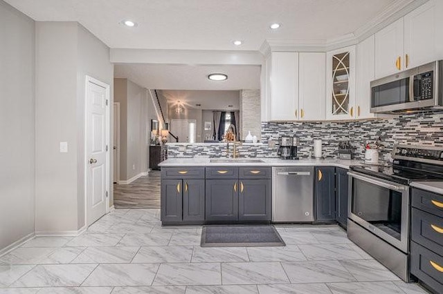 kitchen featuring a sink, stainless steel appliances, light countertops, white cabinetry, and backsplash