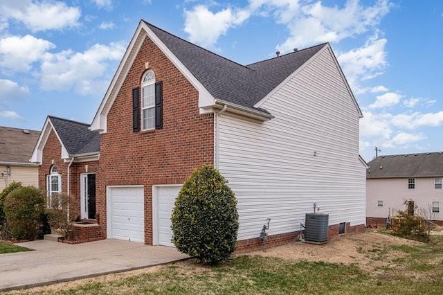 view of property exterior with brick siding, a garage, driveway, and central AC