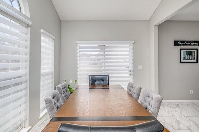 dining space featuring marble finish floor and baseboards