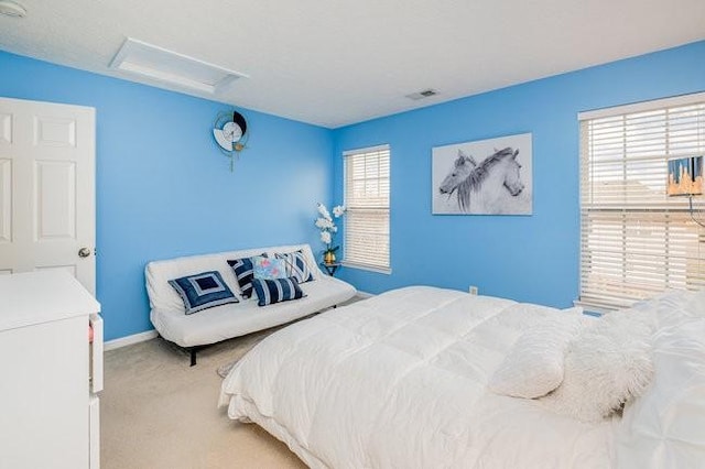 bedroom featuring visible vents, attic access, baseboards, and carpet floors