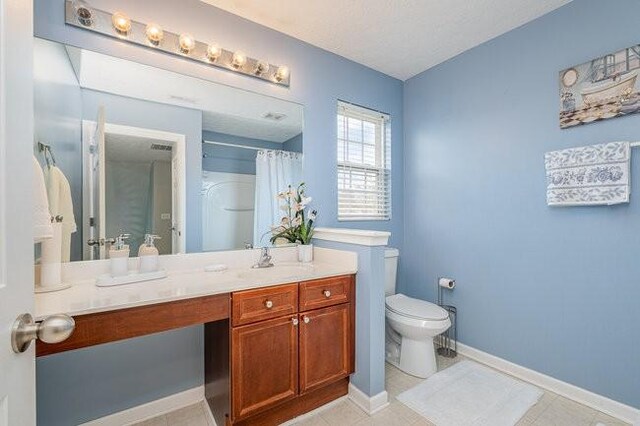 bathroom with tile patterned floors, a shower with curtain, toilet, baseboards, and vanity