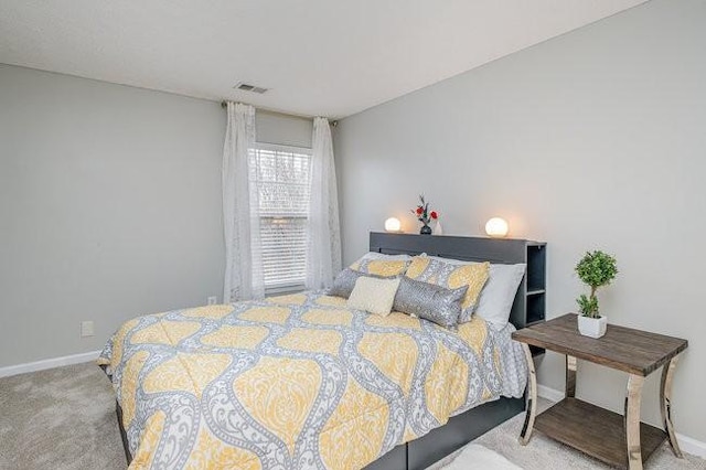 carpeted bedroom with visible vents and baseboards