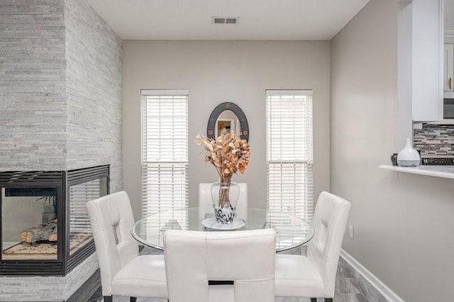 dining area with a fireplace and visible vents