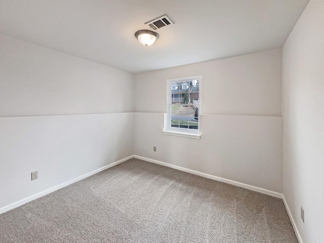 unfurnished room featuring carpet, visible vents, and baseboards