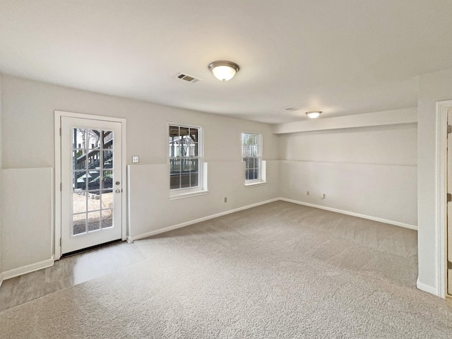 unfurnished room with visible vents, baseboards, and carpet floors