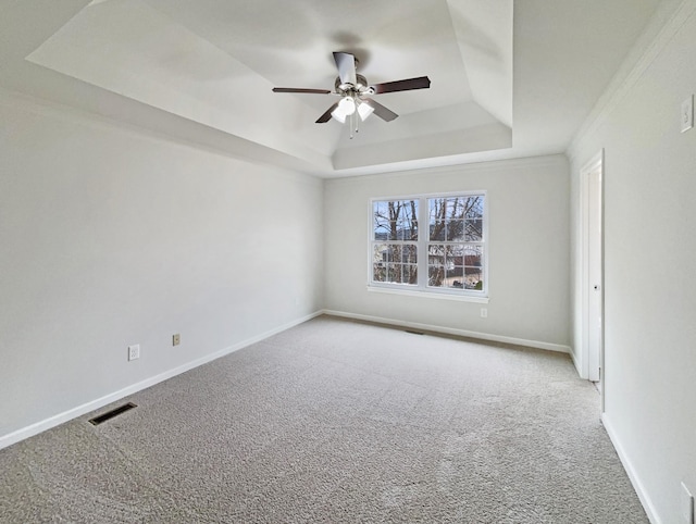 unfurnished room with visible vents, baseboards, carpet flooring, a raised ceiling, and a ceiling fan