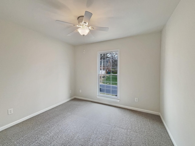 carpeted spare room with ceiling fan and baseboards