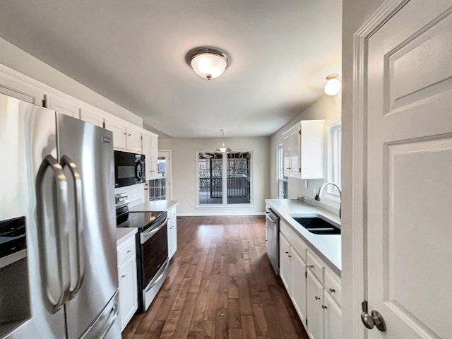 kitchen with a sink, stainless steel appliances, white cabinets, and light countertops