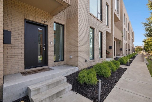 property entrance featuring brick siding