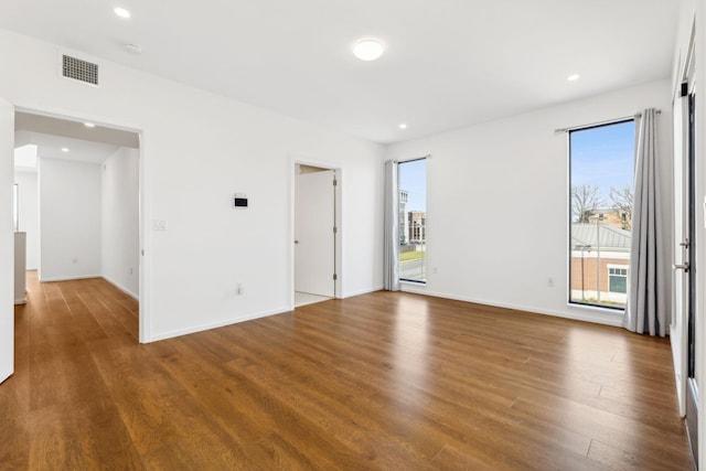 spare room with recessed lighting, visible vents, baseboards, and wood finished floors