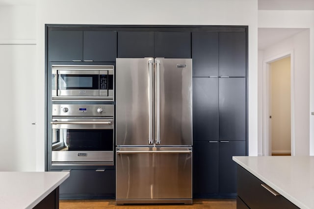 kitchen featuring stainless steel appliances, modern cabinets, light wood-style flooring, and light countertops