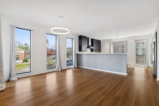 unfurnished living room featuring baseboards and dark wood finished floors