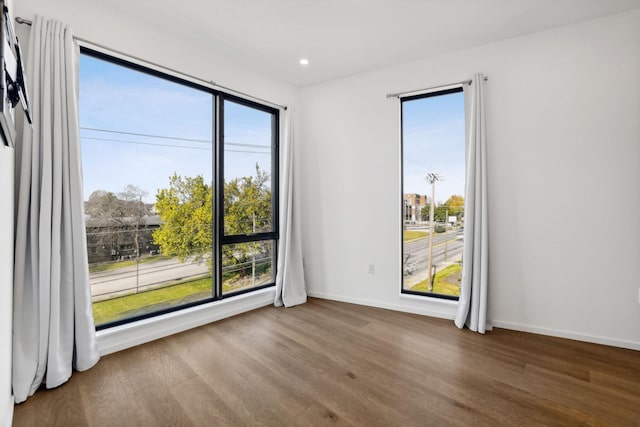 empty room featuring recessed lighting, baseboards, and wood finished floors