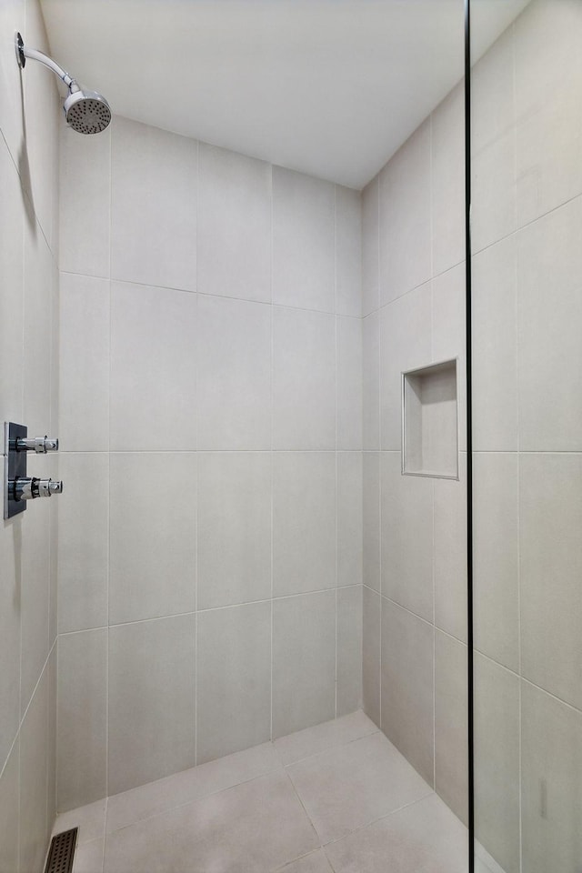 bathroom with a tile shower and visible vents