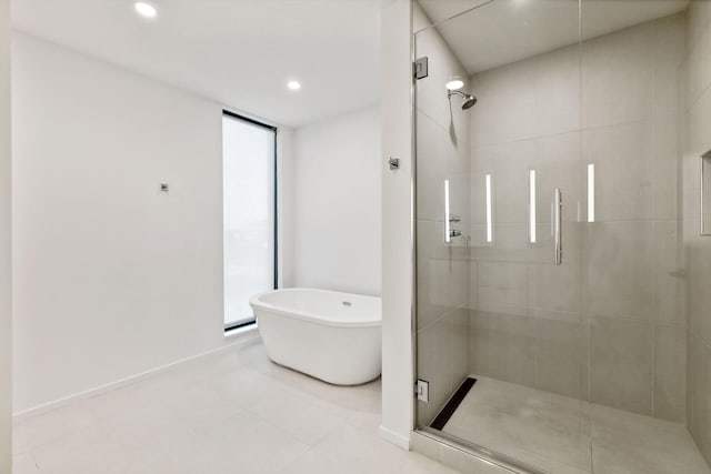 full bath with recessed lighting, a freestanding tub, and a shower stall