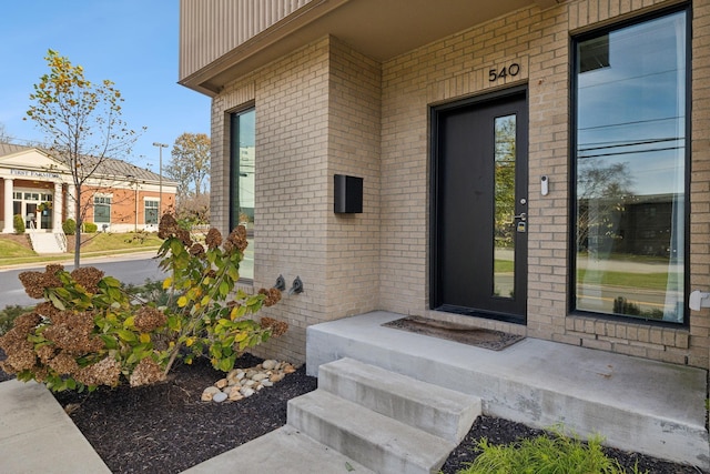 doorway to property featuring brick siding