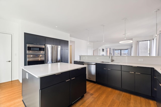 kitchen featuring a sink, stainless steel appliances, modern cabinets, and light countertops