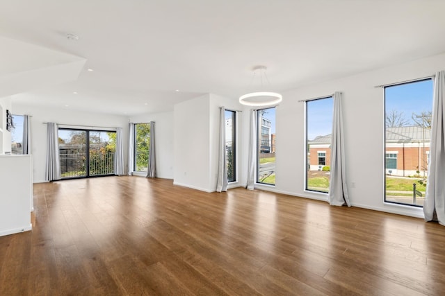 unfurnished living room featuring recessed lighting, baseboards, and wood finished floors