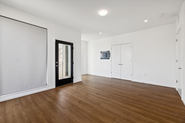 unfurnished room featuring recessed lighting, wood finished floors, and baseboards