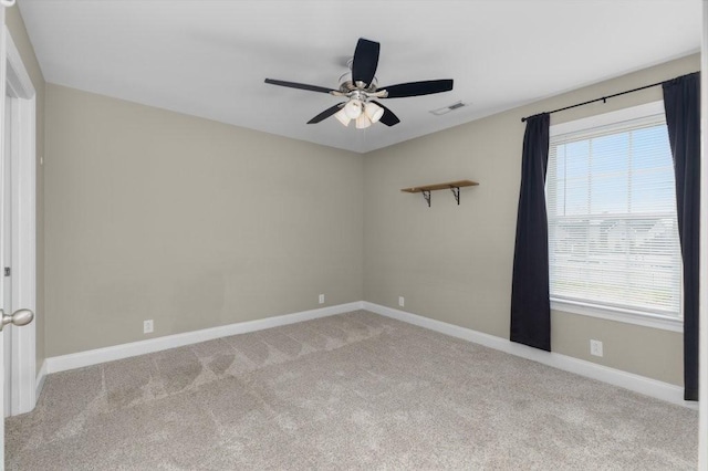 unfurnished room with visible vents, carpet flooring, a ceiling fan, and baseboards