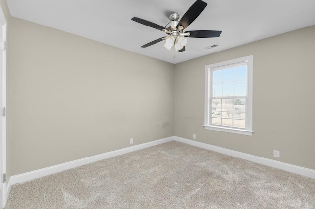 unfurnished room with visible vents, carpet floors, baseboards, and a ceiling fan