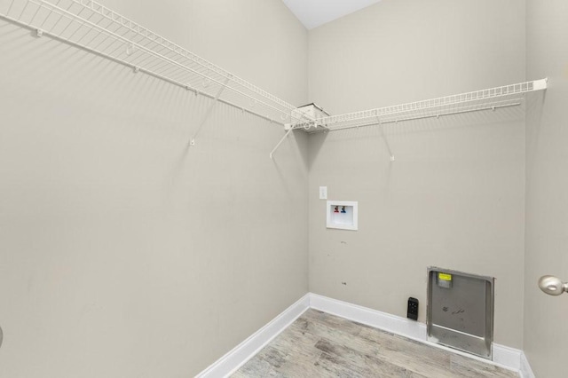 laundry area with laundry area, hookup for a washing machine, wood finished floors, and baseboards