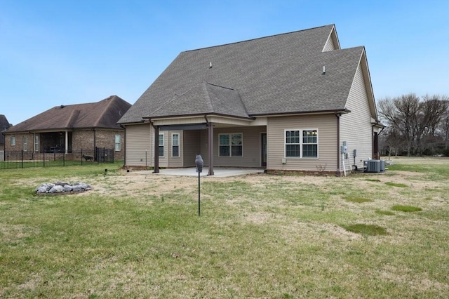 back of house with fence, roof with shingles, cooling unit, a yard, and a patio