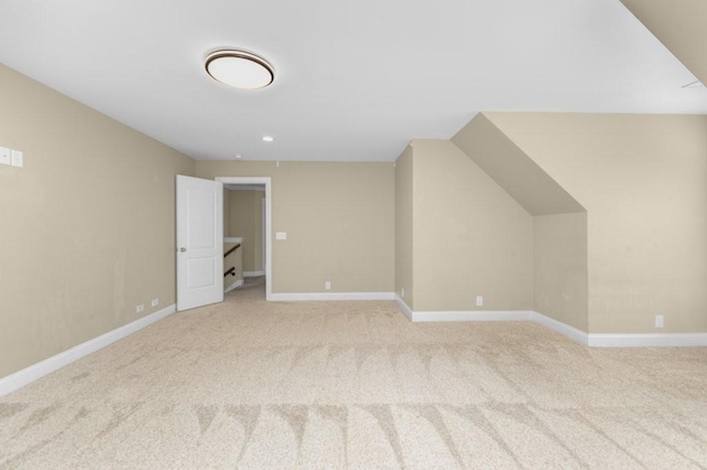 bonus room featuring light carpet and baseboards