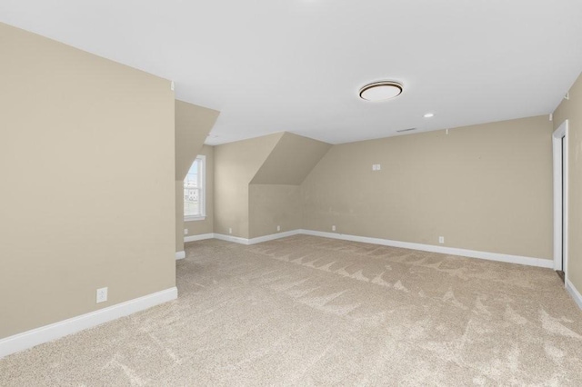 bonus room with baseboards, light carpet, and lofted ceiling