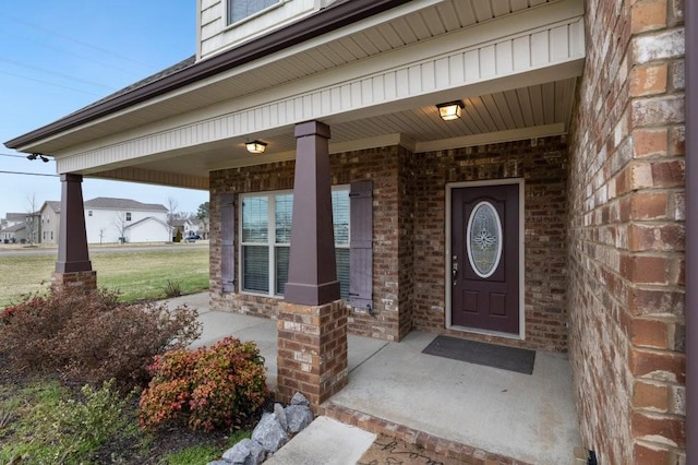 property entrance with brick siding and covered porch