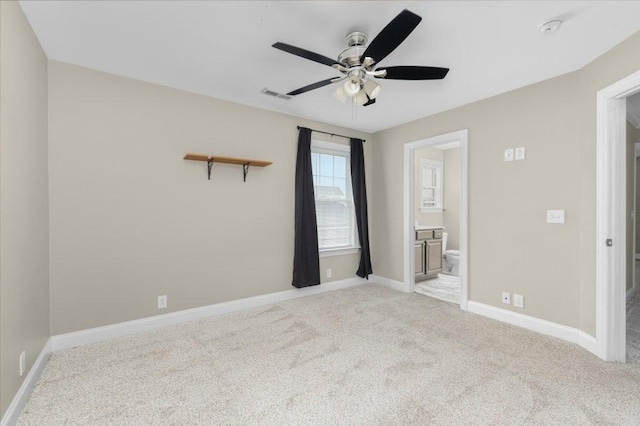 spare room with visible vents, baseboards, light colored carpet, and a ceiling fan