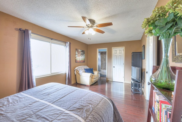 bedroom featuring baseboards, a textured ceiling, a ceiling fan, and wood finished floors