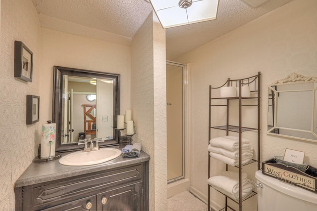 bathroom with vanity, a textured ceiling, and a shower stall