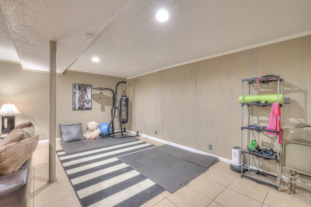 exercise area featuring tile patterned floors, crown molding, baseboards, and a textured ceiling