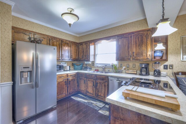 kitchen featuring crown molding, dark wood finished floors, light countertops, stainless steel appliances, and a sink