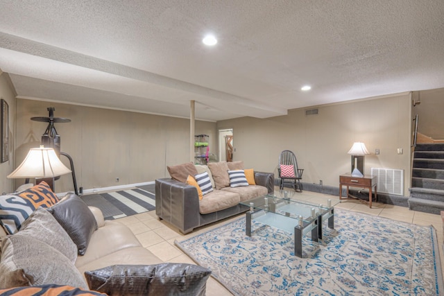 tiled living area with visible vents, recessed lighting, a textured ceiling, and stairs