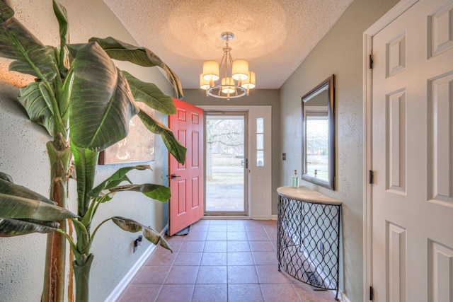 foyer entrance with tile patterned flooring, a notable chandelier, and a textured ceiling