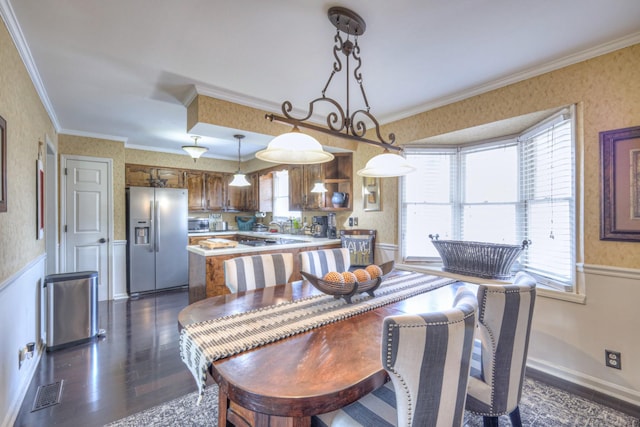 dining space featuring dark wood finished floors, wainscoting, wallpapered walls, and crown molding