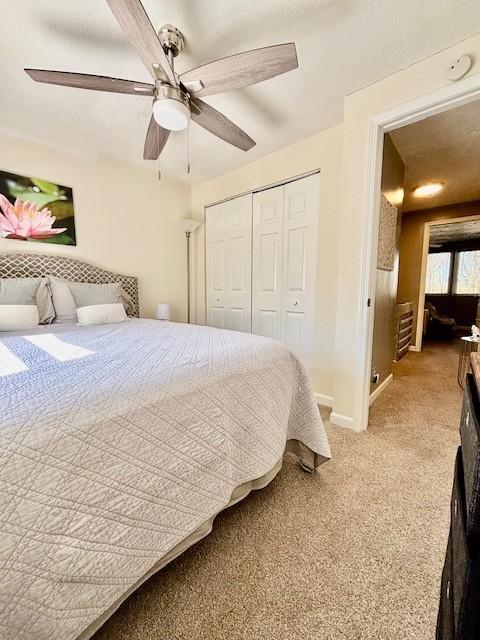 bedroom with ceiling fan, light colored carpet, a closet, and baseboards