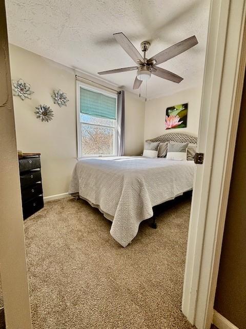 bedroom with carpet flooring, ceiling fan, a textured ceiling, and baseboards