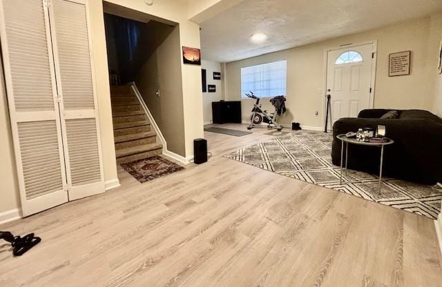 interior space with stairway, wood finished floors, and baseboards