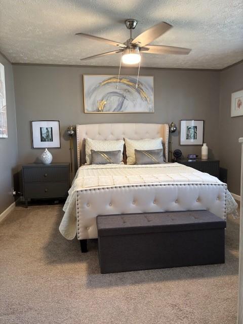 carpeted bedroom with ceiling fan, a textured ceiling, and baseboards