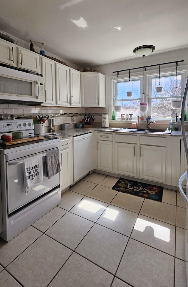 kitchen featuring white cabinetry, white appliances, light tile patterned floors, and backsplash