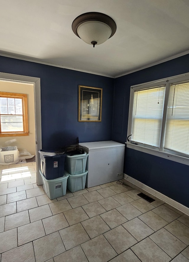 interior space featuring light tile patterned floors, visible vents, and baseboards