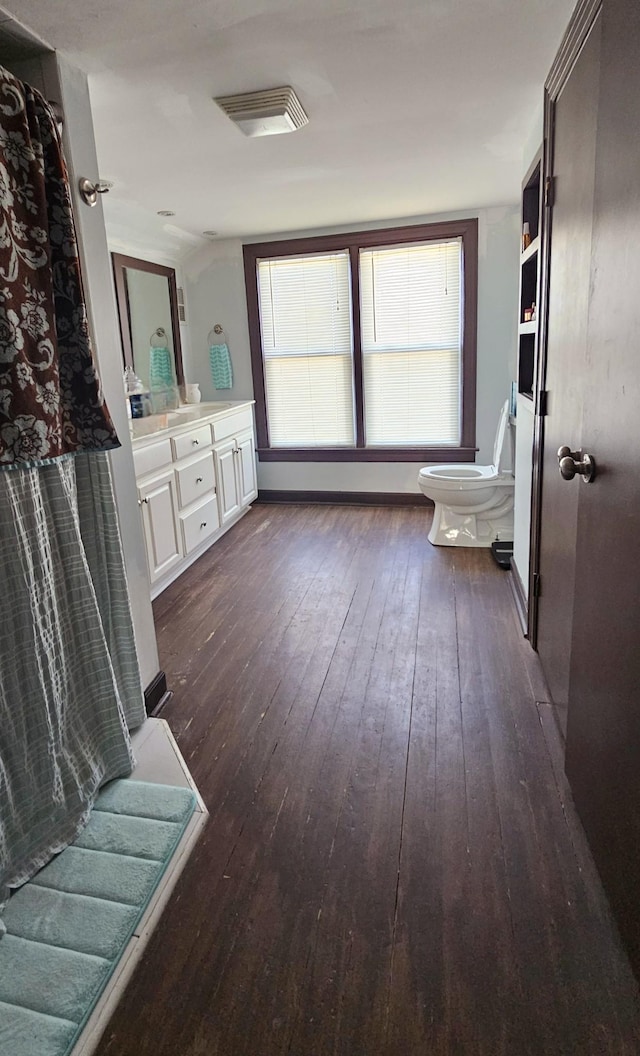 bathroom featuring toilet, vanity, and hardwood / wood-style floors