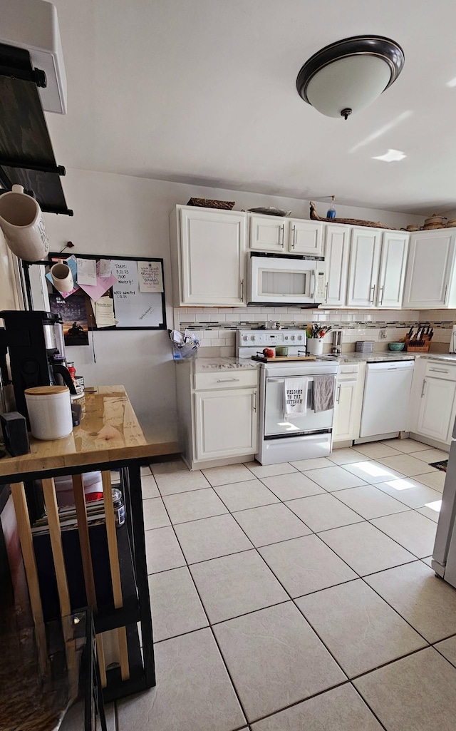 kitchen with light tile patterned floors, white appliances, backsplash, and white cabinetry